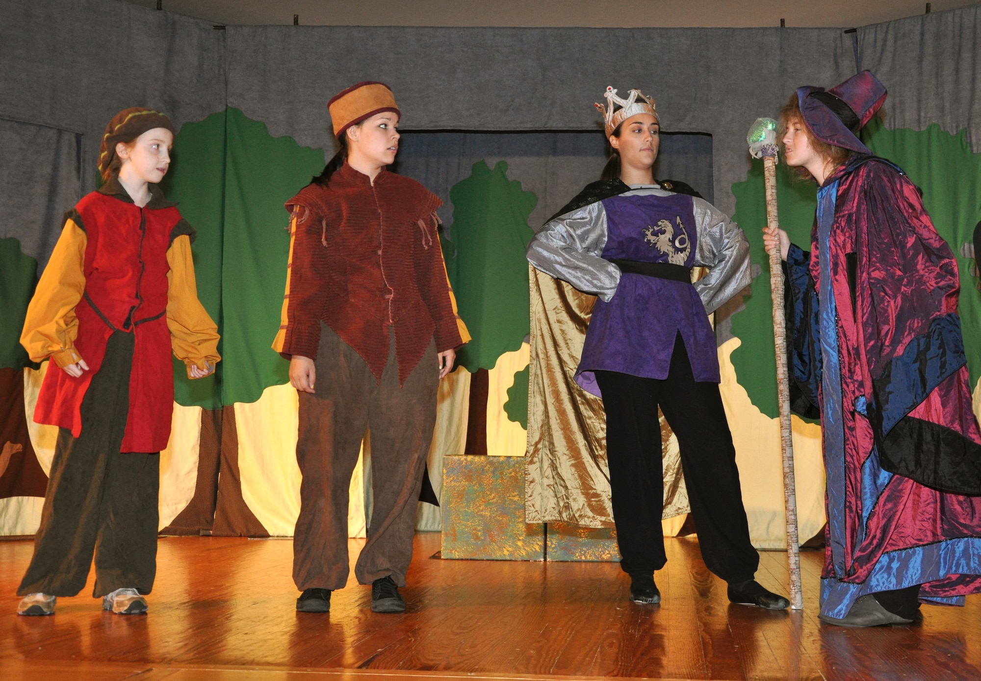 GOODFELLOW AIR FORCE BASE, Texas -- (From left:) Taleisin, played by Katharine Ingalls, Keeper of the Keep, played by Loretta Underwood, King Arthur, played by Emily Hunnemeyer, and Merlin, played by Mary Kate Willis, discuss the problems facing the kingdom during the Missoula Children's Theatre production of King Arthur's Quest Aug. 20 at the base theater here.  More than 50 youths were cast for this year's event, which was rehearsed and showed in one week. (U.S. Air Force photo/Connie Hempel)
