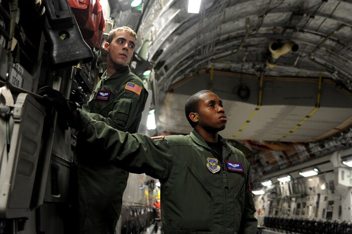 Airman First Class Foster Halcomb and Staff Sgt. Alfonso Rogers watch as U.S. Army Soldiers from the 3rd Battalion, 160th Special Operations Aviation Regiment, Hunter Army Air Field, Ga., guide a MH-60 Blackhawk helicopter from a C-17 Globemaster III at Joint Base Charleston, S.C., Aug 23. (U.S. Air Force photo/ Staff Sgt. Nicole Mickle)  