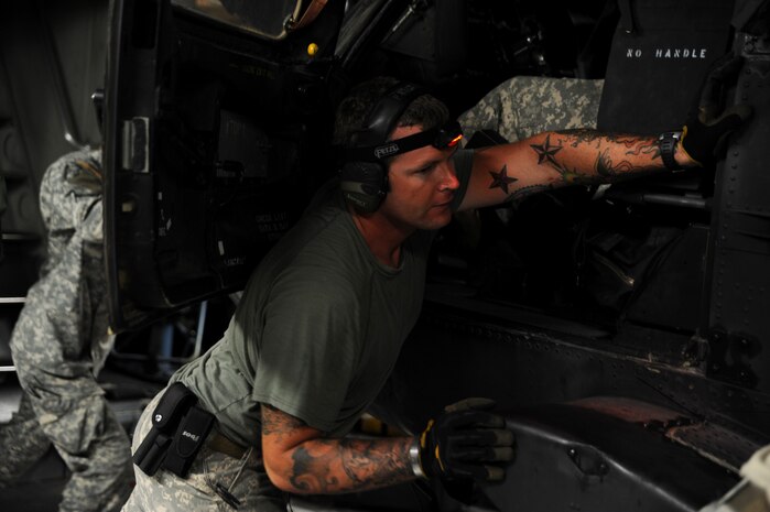 A U.S. Army Soldier from the 3rd Battalion, 160th Special Operations Aviation Regiment, Hunter Army Air Field, Ga., guides a MH-60 Blackhawk helicopter from a C-17 Globemaster III at Joint Base Charleston, S.C., Aug 23.   (U.S. Air Force photo/ Staff Sgt. Nicole Mickle)  
