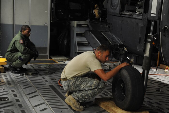 A U.S. Army Air Crew chief from the 3rd Battalion, 60th Special Operations Aviation Regiment, Hunter Army Air Field, Ga. and a loadmaster from the 15th Airlift Squadron prepare to offload a MH-60 Blackhawk helicopter from a C-17 Globemaster III at Joint Base Charleston, S.C., Aug 23. (U.S. Air Force photo/ Staff Sgt. Nicole Mickle)  