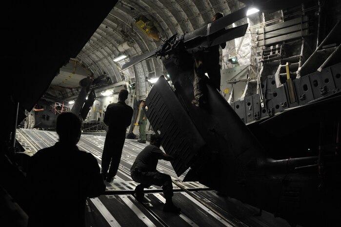 U.S. Army Soldiers from the 3rd Battalion, 160th Special Operations Aviation Regiment, Hunter Army Air Field, Ga. and loadmasters from the 15th Airlift Squadron, prepare to offload a MH-60 Blackhawk helicopter from a C-17 Globemaster III at Joint Base Charleston, S.C., Aug. 23. The joint trainer exercise between the 437th Operations Group and the 160th SOAR was designed to meet both organizations' training needs. The off-station trainer began at Hunter Army Airfield where loadmasters from the 437 OG and the 160th SOAR conducted static helicopter winching of the Blackhawk. After a short flight, they landed at Joint Base Charleston where the helicopters were off-loaded and then assembled. (U.S. Air Force photo/ Staff Sgt. Nicole Mickle)  