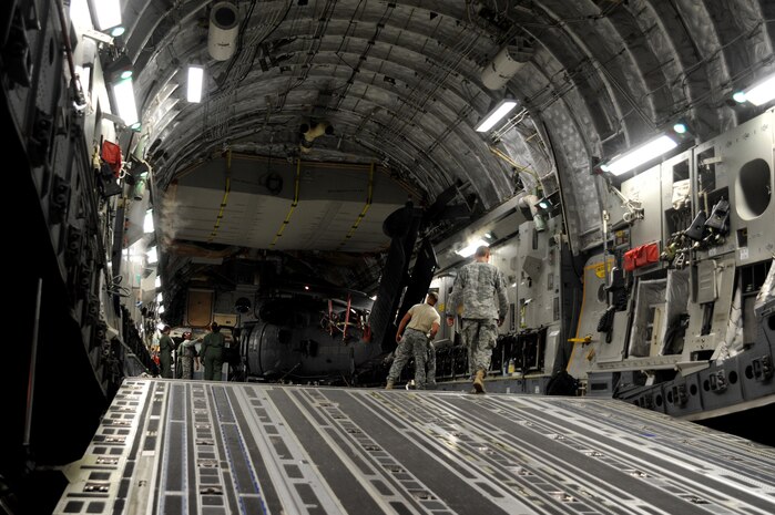 U.S. Army Soldiers from the 3rd Battalion, 160th Special Operations Aviation Regiment, Hunter Army Air Field, Ga. and loadmasters from the 15th Airlift Squadron, guide a MH-60 Blackhawk helicopter from a C-17 Globemaster III at Joint Base Charleston, S.C., Aug. 23. Two helicopters were available to practice multiple load plans and tie-downs on a C-17. After landing at Joint Base Charleston  the helicopters were off-loaded and then assembled.  Five student loadmasters from Joint Base Charleston were able to direct a loading event and members from the 160th SOAR helicopter crews were certified for airlift.(U.S. Air Force photo/ Staff Sgt. Nicole Mickle) 