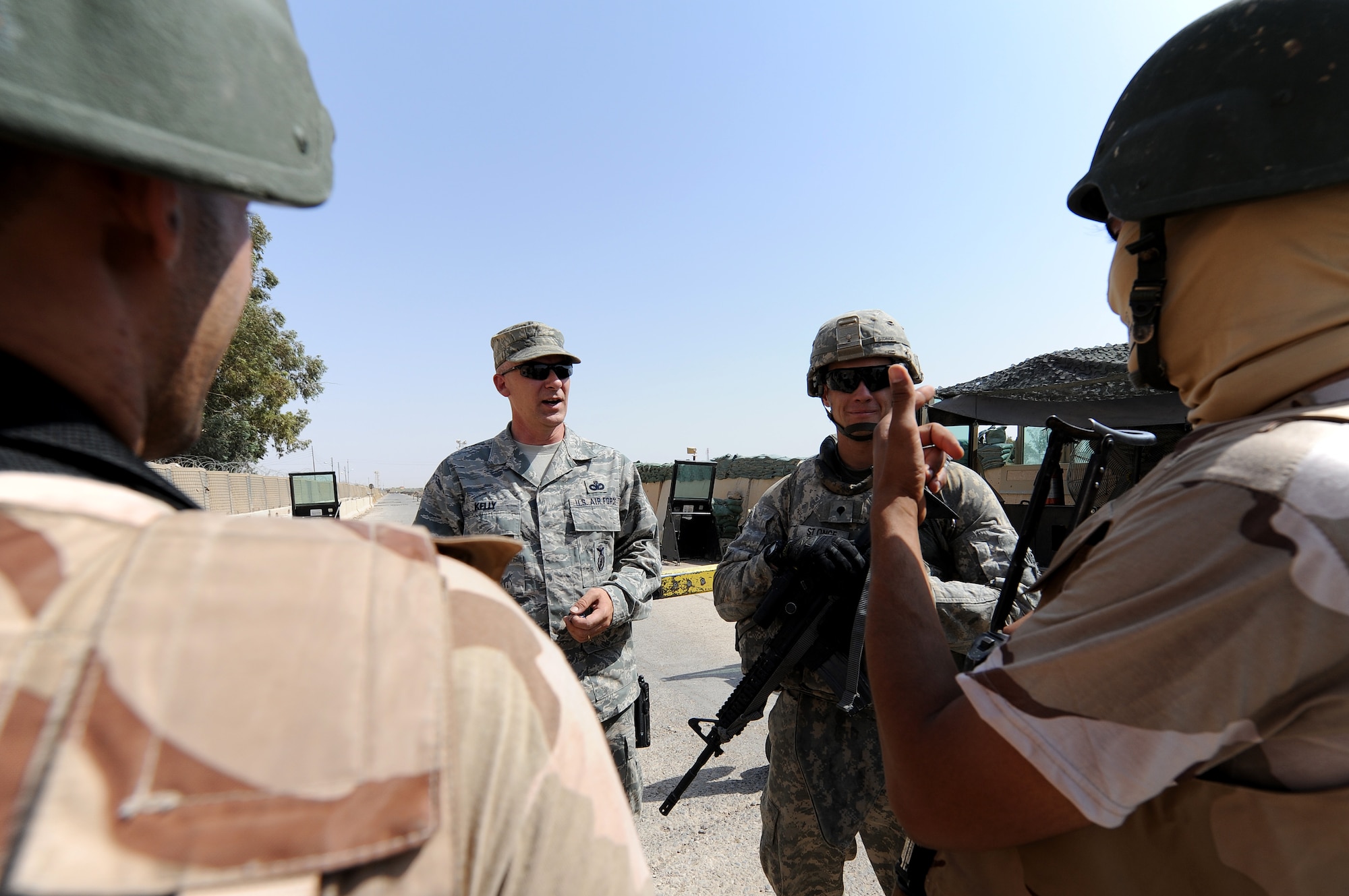 Master Sgt. Daren Kelly, 321st Expeditionary Mission Support Advisory Group Security Forces Advisor, talks to Iraqis about their vehicles searches at Kirkuk Air Base. Sergeant Kelly composed the basic defense manual for the Iraqis to tell them how to conduct base defense. (U.S. Air Force photo by Senior Airman Tristin English)