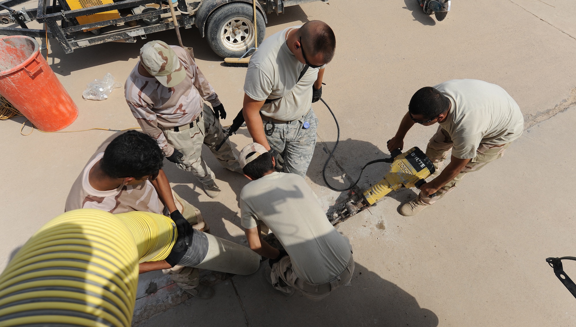Iraqis use a jackhammer to help break up the pavement for a defective patch  on the flightline at Kirkuk Air Base. The 321st Expeditionary Operations Support Squadron responds with the Iraqis, teaching them how to fix defective parts of the flightline.  Without a smooth surface the aircraft will not be able to taxi the runway. (U.S. Air Force photo by Senior Airman Tristin English)