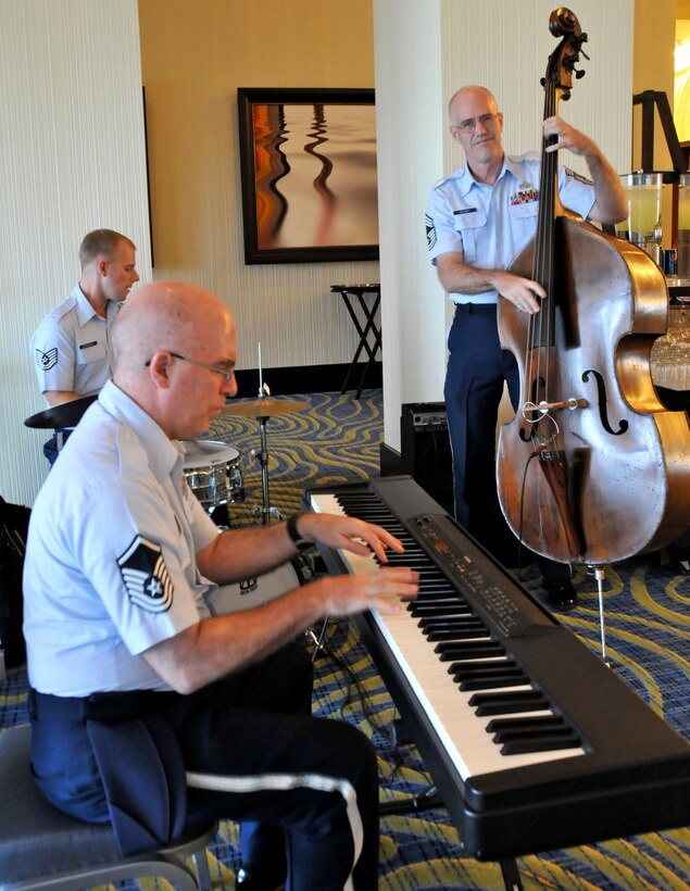 Air Force band members Master Sgt. Steven Erickson (left), Tech. Sgt. David McDonald (center) and Chief Master Sgt. Paul Henry (right) perform during registration hours for the Yellow Ribbon reintegration event, Aug. 19, 2011.  Over 210 Airmen and their families attended the two-day event.  (Air Force photo/Staff Sgt. Kimberly Hickey) 