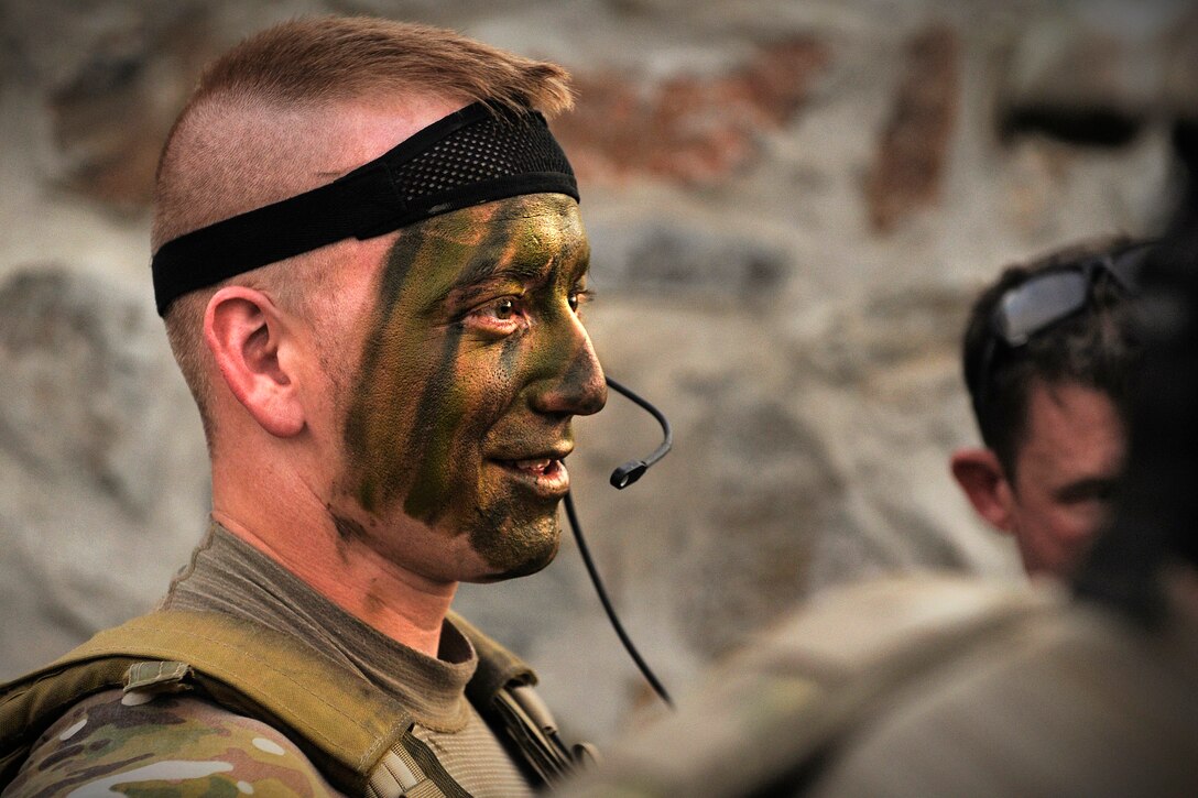 U.S. Army Spc. Dan White watches as fellow soldiers apply camouflage face paint before an operation in the Alingar district of Afghanistan's Laghman province, Aug. 20, 2011. White is assigned to the Laghman Provincial Reconstruction Team. The 
team participated in searching a village thought to house Taliban fighters and other insurgents making roadside bombs.