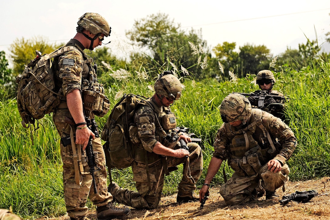 U.S. Army Sgt. 1st Class Brian Lancey, right, shows Staff Sgts. Jason ...