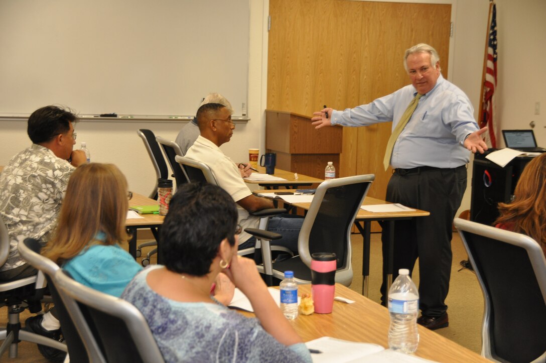 Making an all-encompassing point to the Marine Corps Logistics Base Barstow employees attending his workshop on Advanced Negotiating Strategies, Richard Companara (right) has taught negotiating strategies more than 3,000 times since he began working for Rockhurst University in Kansas City, Mo.