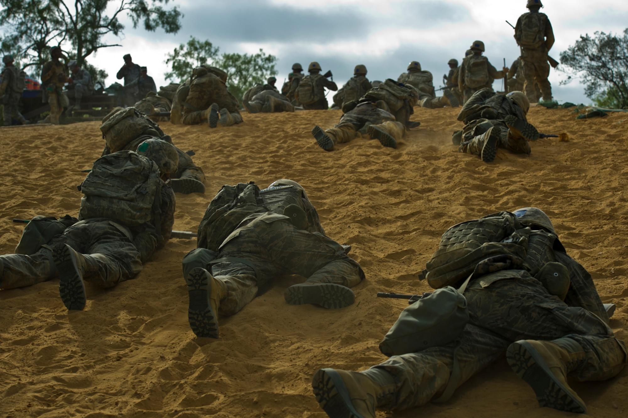 Air Force Basic Military Training trainees low crawl through an obstacle course during the Creating Leaders, Airmen and Warriors course July 27, 2011, at Lackland Air Force Base, Texas. In addition to fitness and combat training, trainees are taught foundational Air Force information, including core values, customs and courtesies, basic policies and procedures, and military studies.  (U.S. Air Force photo/Senior Airman Marleah Miller)