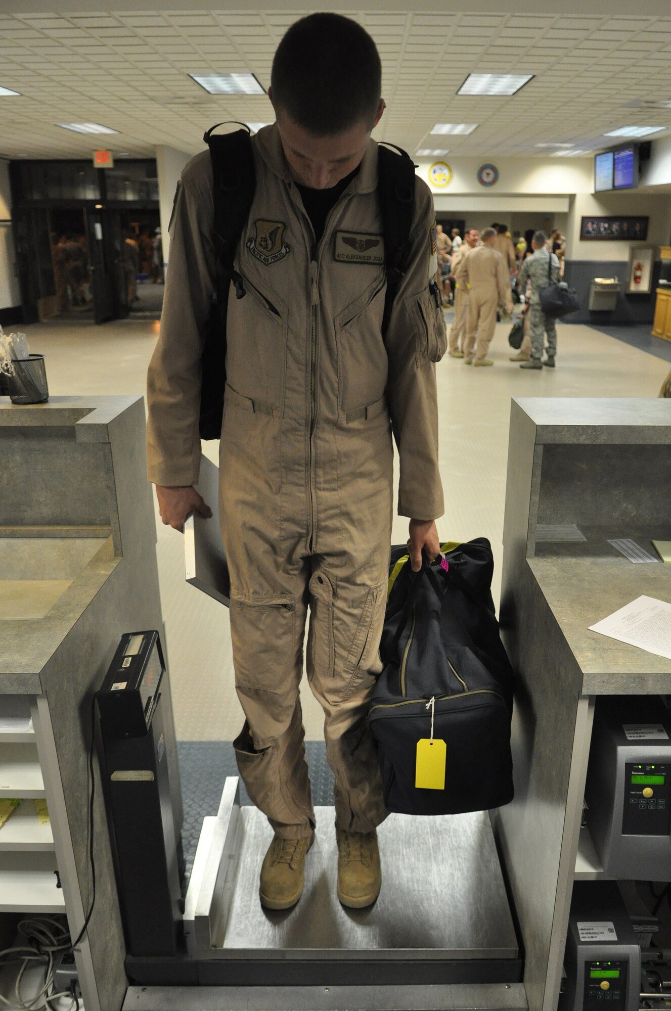 Airman 1st Class Aleksander Joga, 8th Airlift Squadron loadmaster, weighs-in before the squadron left for deployment August 25, 2011, at Joint Base Lewis-McChord, Wash. Airmen assigned to the 8th AS departed McChord Field August 26 for a 120-day deployment in support of the Operations New Dawn and Enduring Freedom.  (U.S. Air Force photo/Airman 1st Class Leah Young)