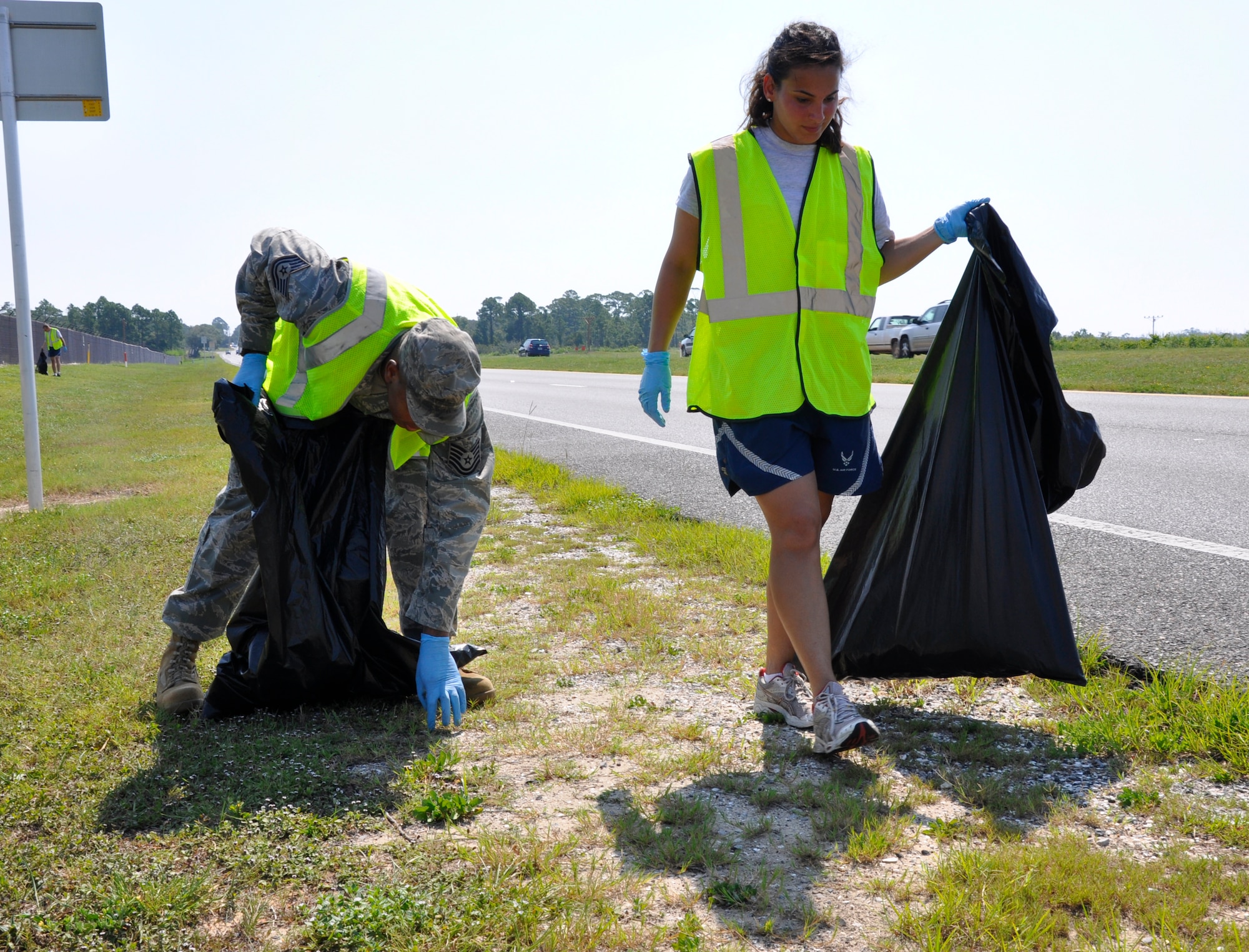 Tech. Sgt. Dominique Dickens, 1st Special Operations Wing Public Affairs, left, and Airman 1st Class Brandy Dirr, 1st SOW/PA, pick up trash as part of a volunteer clean up effort outside of Hurlburt Field, Fla., Aug. 26, 2011. Volunteers spent nearly two hours clearing both sides of the highway outside Hurlburt Field's main gates. (U.S. Air Force photo by Senior Airman Joe McFadden)