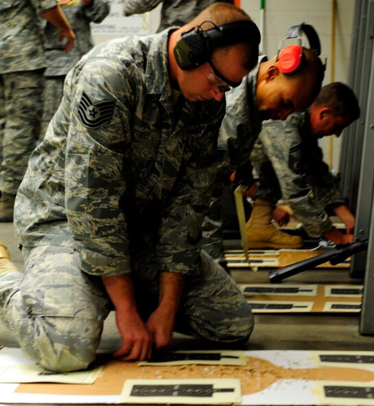 Tech. Sgt. Brian Street tapes his target sheets to the score board to begin an Excellence in Competition match, hosted by the 610th Security Forces Squadron at Naval Air Station Fort Worth JRB, Texas August 24. Competitors were supplied with weapons and score cards before heading to the indoor firing range. Four target sheets were scored and one sheet was used to zero the rifle. (U.S. Air Force photo/Senior Airman Martha Whipple)
