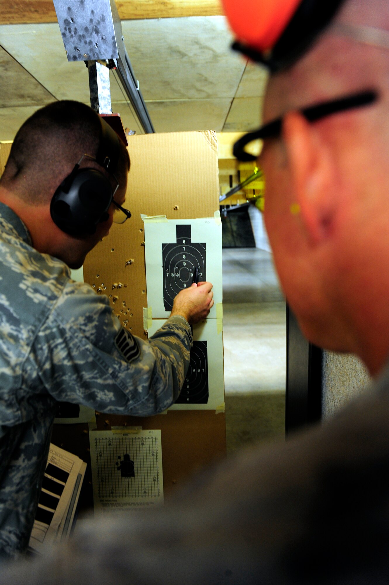 Staff Sgt. Arturo Maldonado, 610th Security Forces Squadron range officer, scored a target sheet for Tech. Sgt. Erik Barber, 610th SFS, during an Excellence in Competition match, hosted by the 610th SFS at Naval Air Station Fort Worth JRB, Texas August 24. Shots fired through the center circle tallied ten points, and each subsequent ring was one point less, down to six points. (U.S. Air Force photo/Senior Airman Martha Whipple)