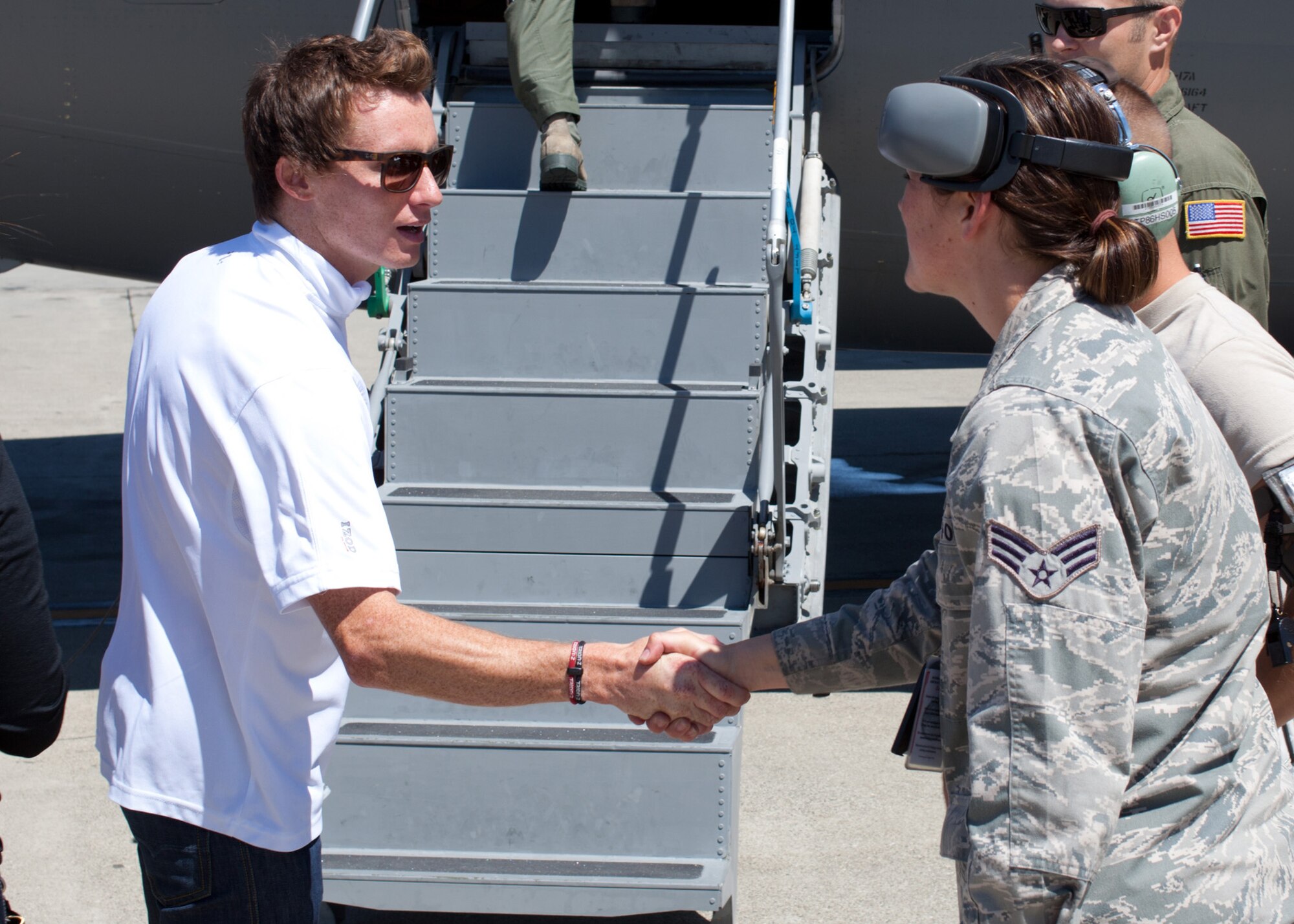 TRAVIS AIR FORCE BASE, Calif. --Mike Conway, driver of the #27 car for the Andretti Autosport IndyCar Team, shakes hands with Senior Airman Jessica Fuchs, a crew chief with the 945th Aircraft Maintenance Squadron prior to a C-17 Globemaster III orientation flight at Travis AFB, Calif., Aug 25, 2011.  Orientation flights for civic leaders, professional athletes and journalists help the American public better understand the contributions of the military to our national defense.  Members of the Andretti Autosport Team observed this routine, local training flight with an Air Force Reserve crew prior to participation at the nearby Grand Prix of Sonoma.  (U.S. Air Force photo / Lt. Col. Robert Couse-Baker)