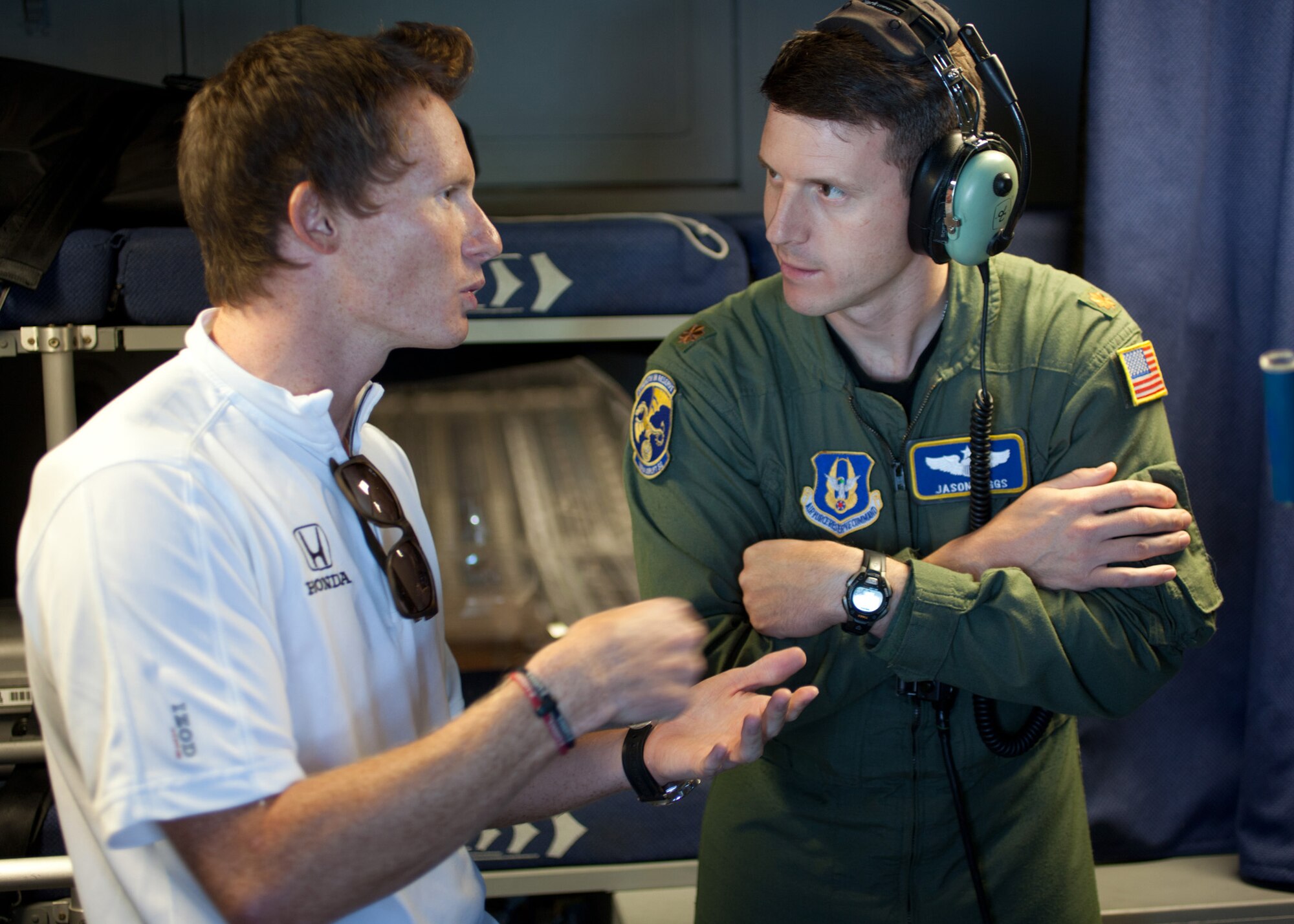 TRAVIS AIR FORCE BASE, Calif. -- Mike Conway, driver of the #27 car for the Andretti Autosport IndyCar Team, speaks with Maj. Jason Biggs, a pilot with the 301st Airlift Squadron, on the flight deck of a C-17 Globemaster III during an orientation flight from Travis AFB, Calif., Aug 25, 2011. Orientation flights for civic leaders, professional athletes and journalists help the American public better understand the contributions of the military to our national defense.  Members of the Andretti Autosport Team observed this routine, local training flight with an Air Force Reserve crew prior to participation at the nearby Grand Prix of Sonoma.  (U.S. Air Force photo / Lt. Col. Robert Couse-Baker)