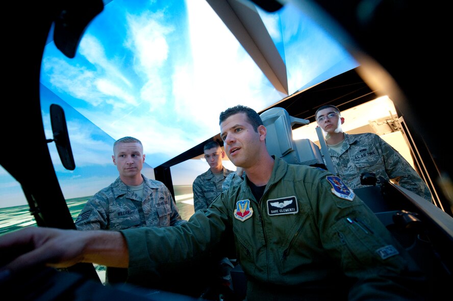 U.S. Air Force Captain Dave Clementi, an A-10C Thunderbolt II pilot with the 75th Fighter Squadron, uses a flight simulator to inform students in the Attack Control Systems Course how equipment can be used in real world situations. Use of the simulator as a teaching tool showed the students how vital their equipment systems are to the mission. (U.S. Air Force Photo by Staff Sgt. Joshua J. Garcia/Released)