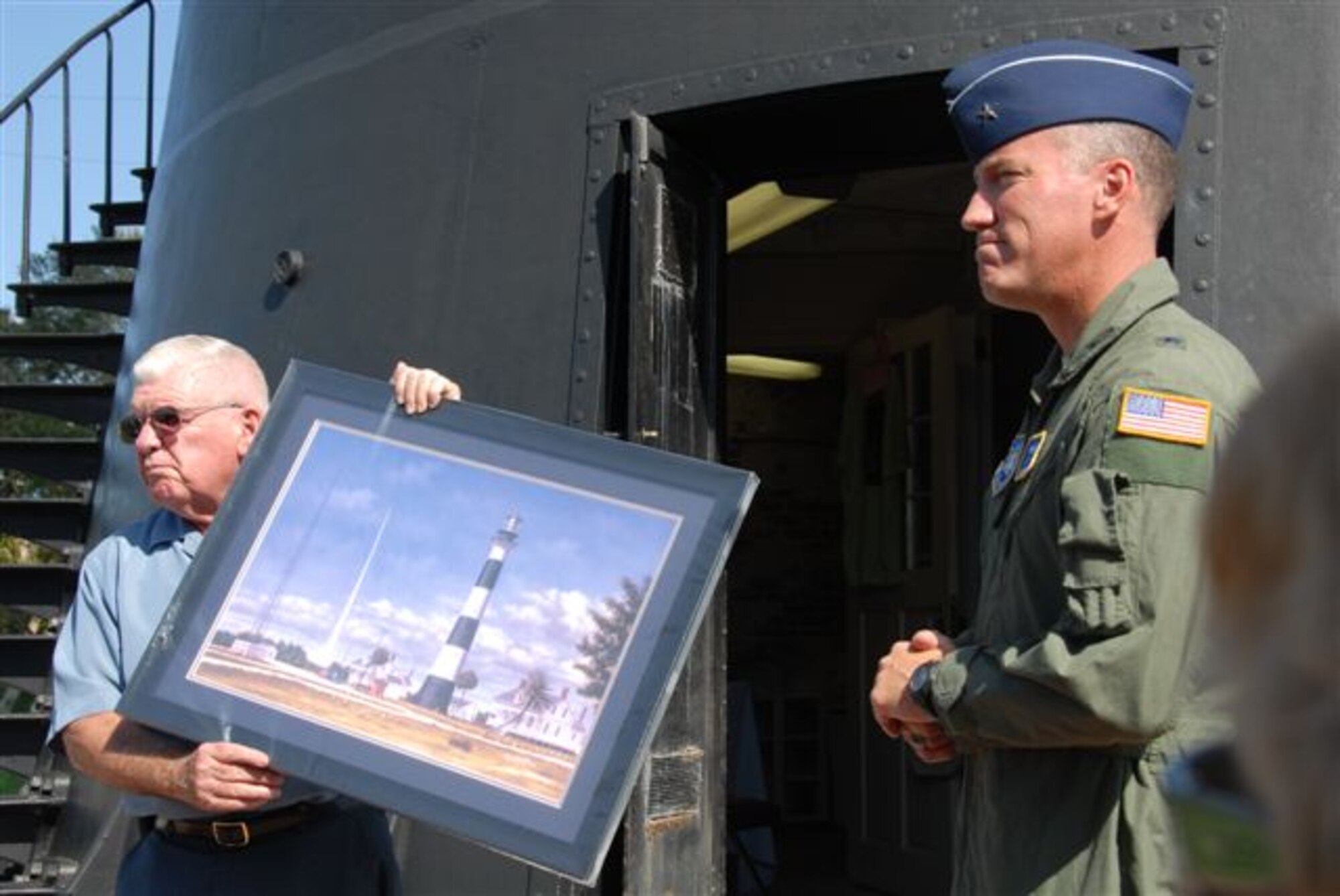 Coast Guard Rear Admiral (Ret.) Bob Merrilees,
Cape Canaveral Lighthouse Foundation
president, honors Brig. Gen. Ed Wilson,
45th Space Wing Commander, for his support
of the landmark lighthouse. The foundation’s
farewell to General Wilson coincided with an
Aug. 18 public tour of Cape Canaveral Air Force
Station, now offered by the wing free of charge
twice per week, on Wednesdays and Thursdays.
For tour details, call 494-5945 or email
ccafstours@patrick.af.mil. (Courtesy photo/Ginny Davis, Cape Canaveral Lighthouse Foundation)