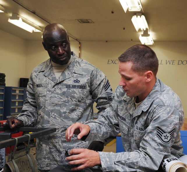Chief Master Sgt. Rory Wicks, 56th Fighter Wing command chief, looks on as Staff Sgt. Mitchell Lawhorn, 56th Component Maintenance Squadron egress system technician, shows him the environmental sensor of an F-16 Fighting Falcon ejection seat Aug. 17 at Luke Air Force Base.  The environmental sensor detects air speed and altitude and relays it back to the recovery sequencer to ensure proper ejection mode selection.  (U.S. Air Force photo by Senior Airman Darlene Seltmann)