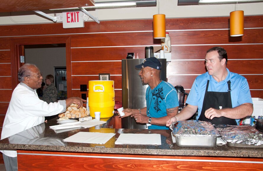 Herman (left) and Montel (center) Williams and Jimmy Stovall, prepare for the luncheon they provided at the Charles C. Carson Center for Mortuary Affairs Aug. 25, 2011. Montel's father made his special Crab cakes and Stovall provided ribs and pulled pork. (U.S. Air Force photo/Tech. Sgt. Marvin Moore)