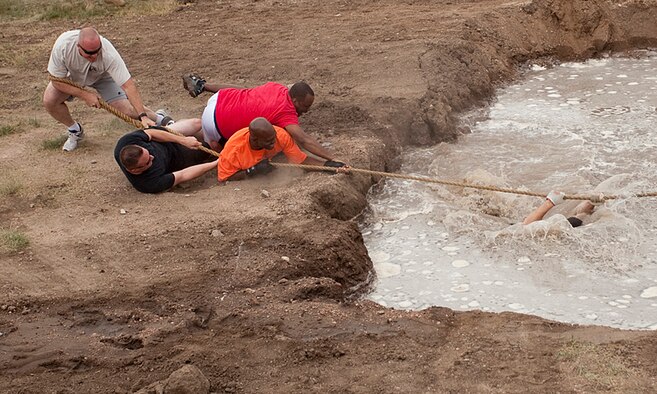 Participants in the tug-of-war competition lose a teammate in the water during Frontiercade held at the Argonne Parade Field here Aug. 19. Some other events of Frontiercade included a 5K race, a buffalo chip toss and a human wheelbarrow race. (U.S. Air Force photo by Matt Bilden)