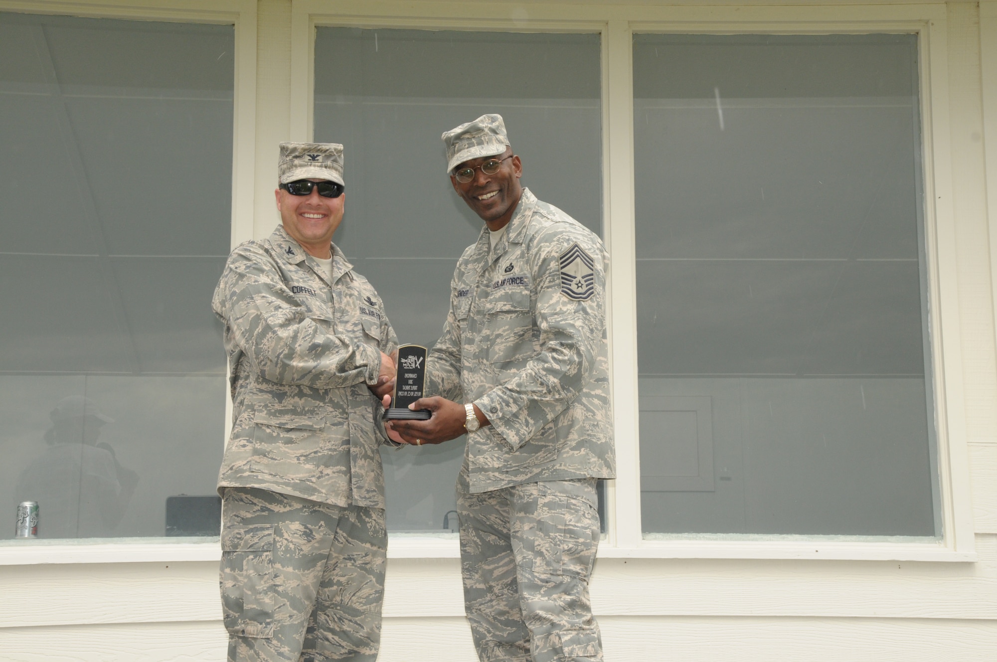 Col. Christopher Coffelt, 90th Missile Wing commander, presents Chief Master Sgt. Patrick Lavender, 90th Force Support Squadron chief enlisted manager, the award for the 2011 Warren Xtreme challenge for the Triple Threat team comprised of the 90th Contracting Squadron, 90th Communications Squadron and 90th FSS during Frontiercade 2011. (U.S. Air Force photo by Blaze Lipowski)