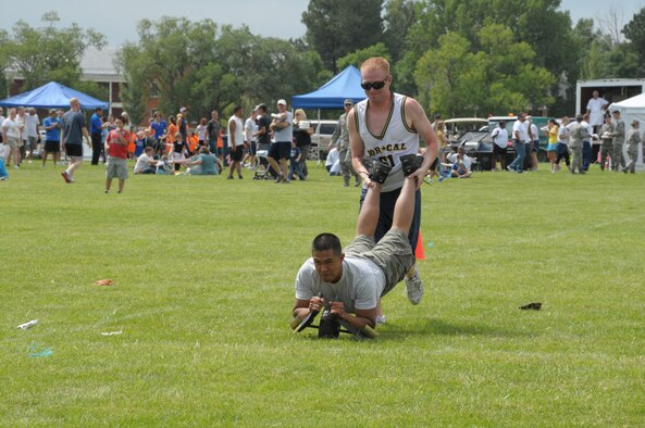 Senior Airman Jon Huff, 90th Maintenance Operations Squadron, pushes his teammate Senior Airman Justin Natan, 90th Missile Maintenance Squadron, during the human wheelbarrow contest Aug. 19 during Frontiercade 2011. (U.S. Air Force photo by Blaze Lipowski)