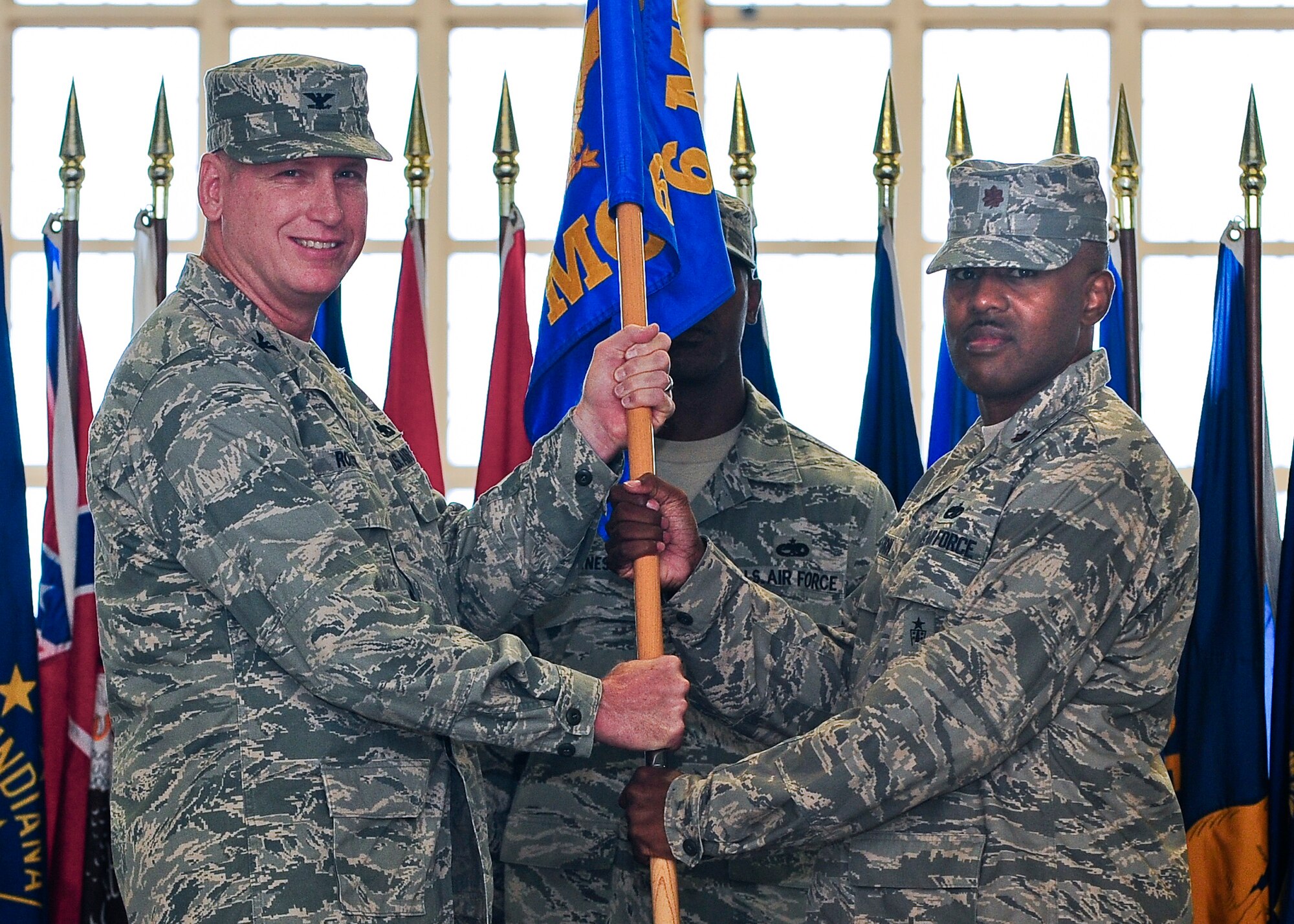 Col. Barry Roeper, 6th Maintenance Group commander, passes the guideon to Maj. Rofelio Grinston as he accepts command of the 6th Maintenance Operations Squadron during a Change of Command Ceremony July 8, 2011 in Hangar 3 at MacDill Air Force Base, Fla.(U.S. Air Force photo by Airman 1st Class Melanie Bulow Gonterman)