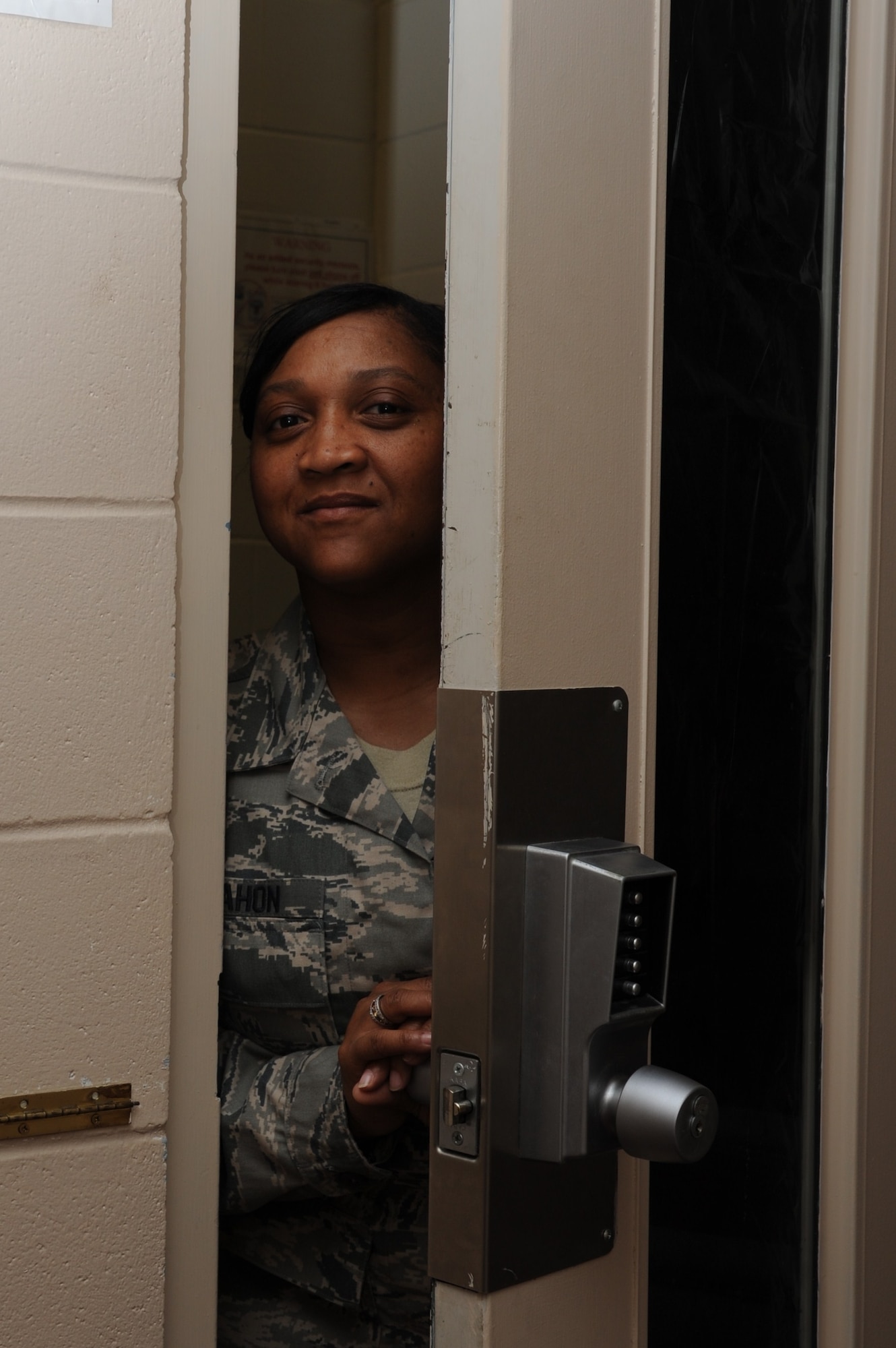 Tech. Sgt. Daphne McMahon, 14th Flying Training Wing Command Post, peeks out of a secured door on Aug. 24. (U.S. Air Force photo/Airman 1st Class Chase Herick)