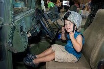 HANSCOM AIR FORCE BASE, Mass. – Cole Anderson tries on a helmet while sitting in a Humvee at the Tactical Air Control Party display during the Electronic Systems Center Showcase in the Aero Club Hangar Aug. 22. The showcase highlighted the global reach of ESC through displays and demonstrations from all the directorates, the 66th Air Base Group and Air Force Recruiting and was an opportunity to see how the work done here gets put in action for the nation’s warfighters. (U.S. Air Force photo by Rick Berry)