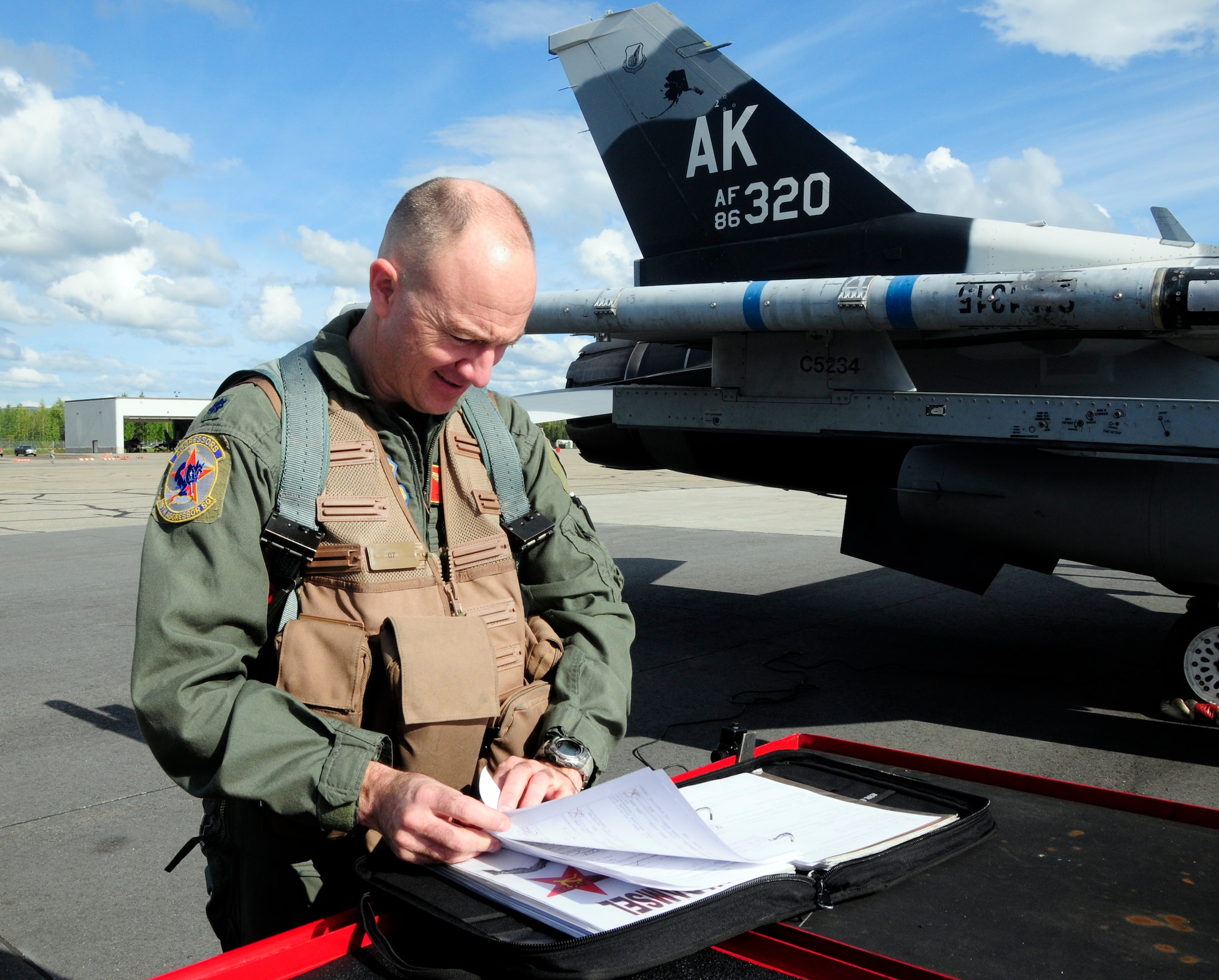 Aggressor pilot Lt. Col. Todd Emmons reviews aircraft maintenance forms before a flight here Monday. The aggressors act as the red forces, or bad guys, in training missions during RED FLAG-Alaska. Colonel Emmons is the 18th Aggressor Squadron commander. (U.S. Air Force photo/Senior Airman Rachelle Coleman)