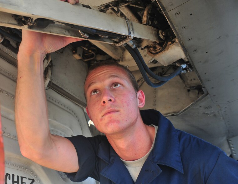U.S. Air Force Airman 1st Class Mathew Hollenback, 55th Aircraft Maintenance Unit crew chief, inspects the bottom of a jet to make sure everything is in order and functioning properly at Shaw Air Force Base, S.C. Aug. 19, 2011. Maintainers ensure jets are in order and up to date so the pilots stay safe. (U.S. Air Force photo by airman 1st Class Ashley Gardner/ Released)