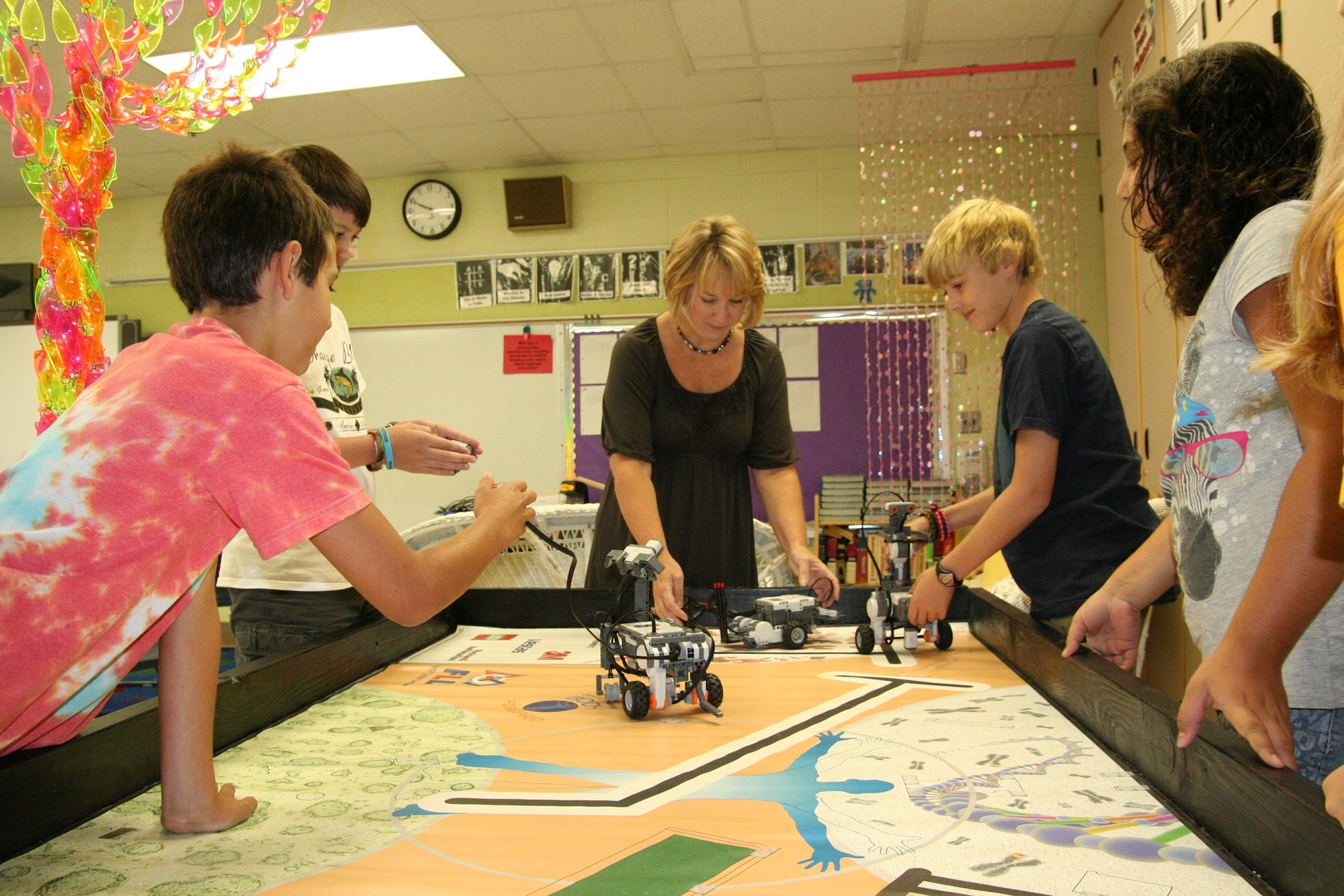 Rebecca Hill, center, helps sixth- and seventh-grade students, from left, Frank Rossi, Michael Boster, Adam Peck and Daria Selkirk program robots to develop science and math skills in her gifted-education class at Maxwell Elementary/Middle School. Department of Defense Education Activity named Hill teacher of the year for the Georgia/Alabama district. (Air Force photo/Kelly Deichert)