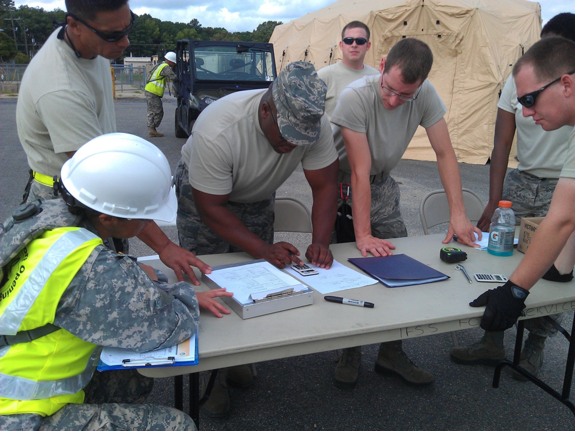 Soldiers from the 690th RPOE, 597th Trans. Bde., and Airmen from the 633rd LRS, 633rd MSG, 633rd Air Base Wing, and the 71st APS, 512th MSG, 512th Airlift Wing, calculate center of balance weights and verify joint inspection paperwork. (U.S. Army photo by Spc. Anthony Burgess/RELEASED)