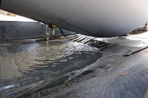 Water drains out of a CFM International CFM56 engine (F108 military designation) on a KC-135R Stratotanker during an ECO System engine cleaning at Scott AFB, Ill., on August 24, 2011. A collector placed beneath the engine catches the deionized, chemical free water allowing it to be recycled back into the ECO System for filteration and reuse. The 126th Air Refueling Wing, Illinois Air National Guard, is participating in the engine wash as a fuel conservation measure. Washing the engine is expected to reduce the Exhaust Gas Temperature (EGT) margin by 5-6 degrees resulting in fuel savings and longer engine life. (U.S. AF photo by Master Sgt. Ken Stephens) (Released)