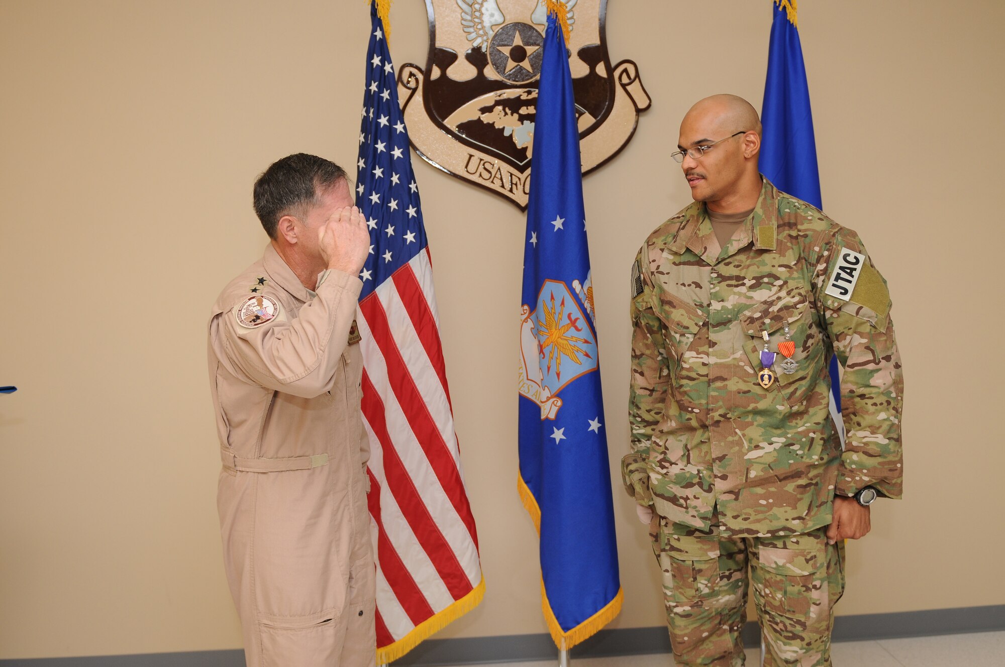 Senior Airman Jorge Henry, a joint terminal attack controller deployed to the 817th Expeditionary Air Support Operations Squadron, is saluted by Lieutenant General David Goldfein, commander of U.S. Air Forces Central Command, after being presented a Purple Heart for wounds sustained during a nine-hour firefight in Afghanistan August 12, 2011. Goldfein was once shot down himself, and honored the JTAC with a salute to show his appreciation for being rescued by Airmen like Henry. Henry, deployed from the 25th Air Support Operations Squadron, Schoefield Barracks, Hawaii, sustained a gunshot wound to the hand early in the battle and continued to call in close air support throughout the firefight. He also received the Air Force Combat Action Medal. (U.S. Air Force photo by Master Sergeant Gary J. Rihn)