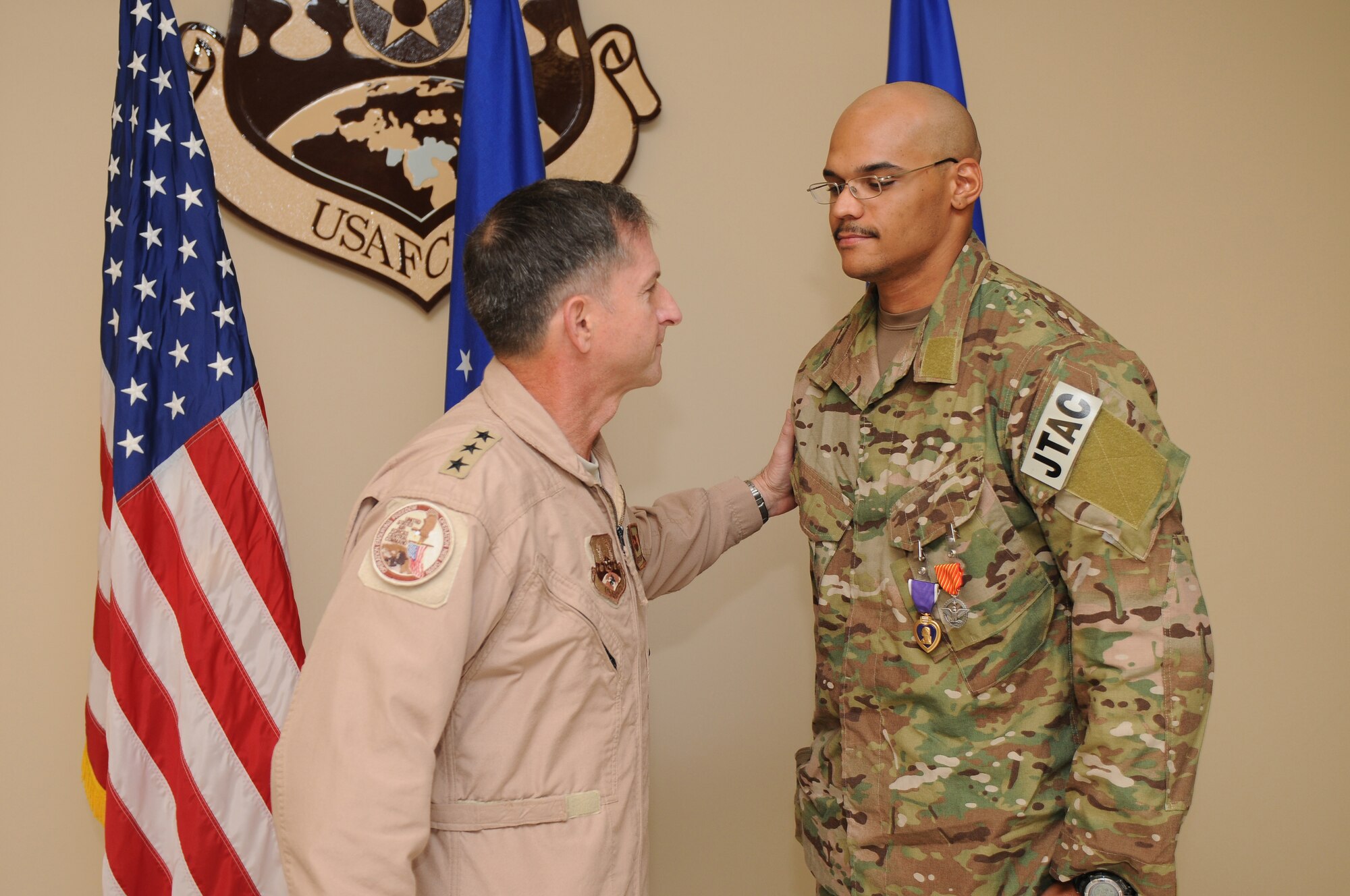 Senior Airman Jorge Henry, a joint terminal attack controller deployed to the 817th Expeditionary Air Support Operations Squadron, is presented a Purple Heart by Lieutenant General David Goldfein, commander of U.S. Air Forces Central Command, for wounds sustained in a nine-hour firefight in Afghanistan August 12, 2011. Henry, deployed from the 25th Air Support Operations Squadron, Schoefield Barracks, Hawaii, sustained a gunshot wound to the hand early in the battle and continued to call in close air support throughout the firefight. He received the Purple Heart and an Air Force Combat Action Medal August 25, 2011, while recuperating in Southwest Asia.(U.S. Air Force photo by Master Sergeant Gary J. Rihn)