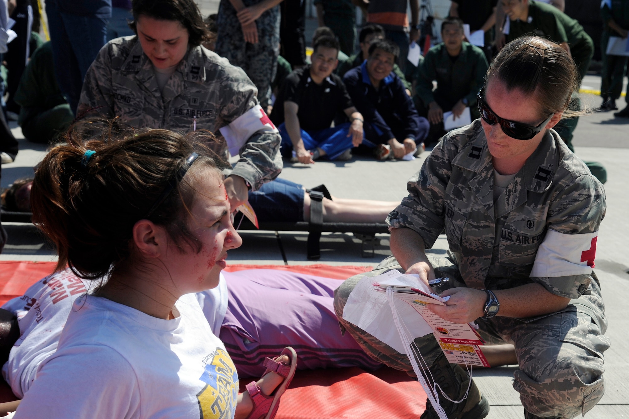 MISAWA AIR BASE, Japan -- Capt. Mandy Miller, right, 35th Medical Group, assesses a role player of a simulated Air Force F-16 Fighting Falcon plane crash on the flightline here during a major accident response exercise here Aug. 26. The MARE prepared emergency responders for the possibility of a real world accident during the upcoming Misawa Air Fest. (U.S. Air Force photo/Tech. Sgt. Marie Brown)