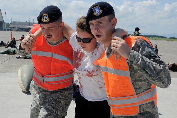 MISAWA AIR BASE, Japan -- Members of the 35th Security Forces Squadron transport a role player from the flightline during a major accident response exercise here Aug. 26. The MARE prepared emergency responders for the possibility of a real world accident during the upcoming Misawa Air Fest. (U.S. Air Force photo/Tech. Sgt. Marie Brown)