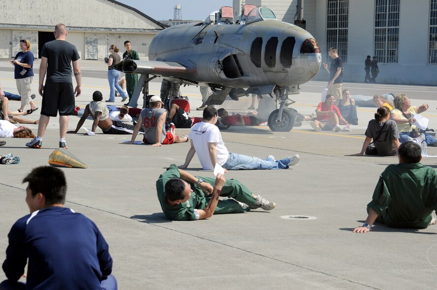 MISAWA AIR BASE, Japan -- Role players of a simulated Air Force F-16 Fighting Falcon crash wait for medical care on the flightline during a major accident response exercise here Aug. 26. Approximately 100 volunteers participated as simulated role players during the exercise. (U.S. Air Force photo/Tech. Sgt. Marie Brown)