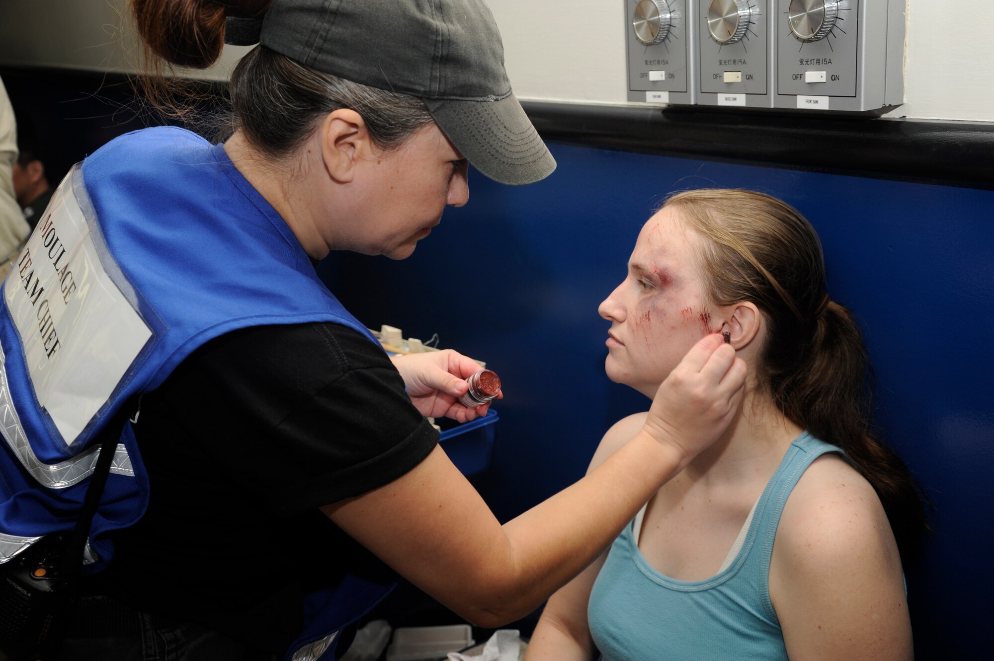 MISAWA AIR BASE, Japan -- Elaine Ortiz-Harrison, moulage team chief, creates simulated injuries on a role player participating in a major accident response exercise Aug. 26. Moulage gives the exercise a more realistic feeling and look. (U.S. Air Force photos/ Tech. Sgt. Marie Brown)