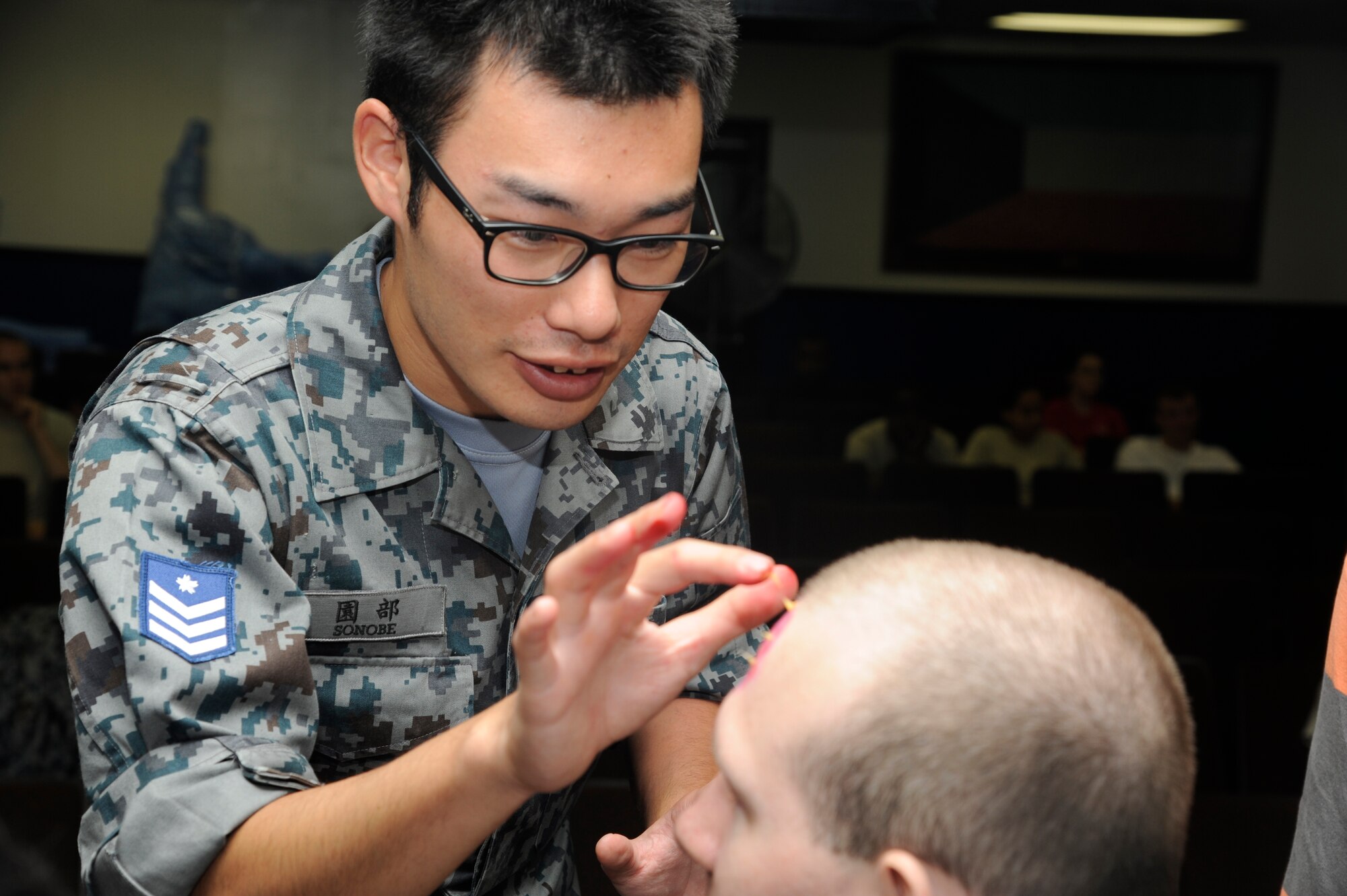 MISAWA AIR BASE, Japan -- Japan Air Self-Defense member applies moulage makeup to a role player in preparation for a major accident response exercise Aug. 26. The MARE is used to provide training to improve real world readiness skills. (U.S. Air Force photo/ Tech. Sgt. Marie Brown)