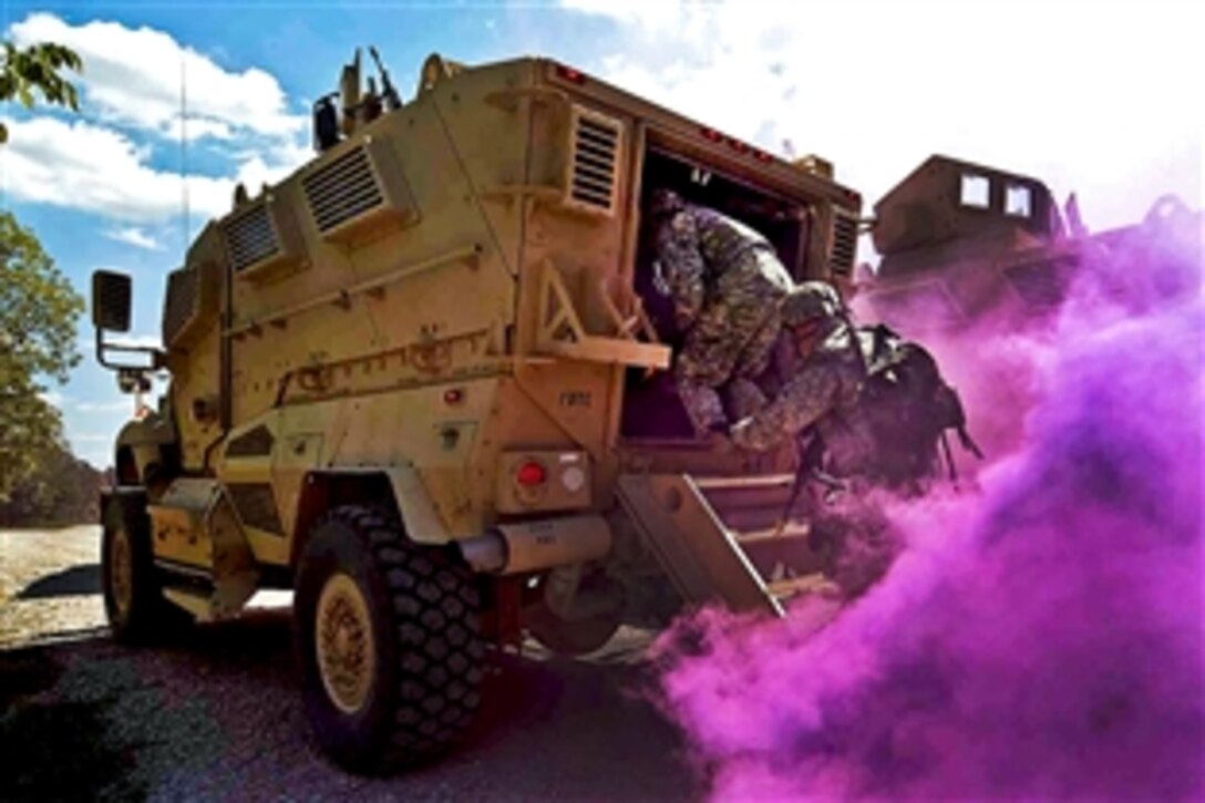 Soldiers scan for roadside bombs and board a mine-resistant, ambush-protected vehicle during a combat training exercise at the Joint Maneuver Training Center on Camp Atterbury, Ind., Aug. 22, 2011. The soldiers are assigned to the 713th Combat Engineer Company.