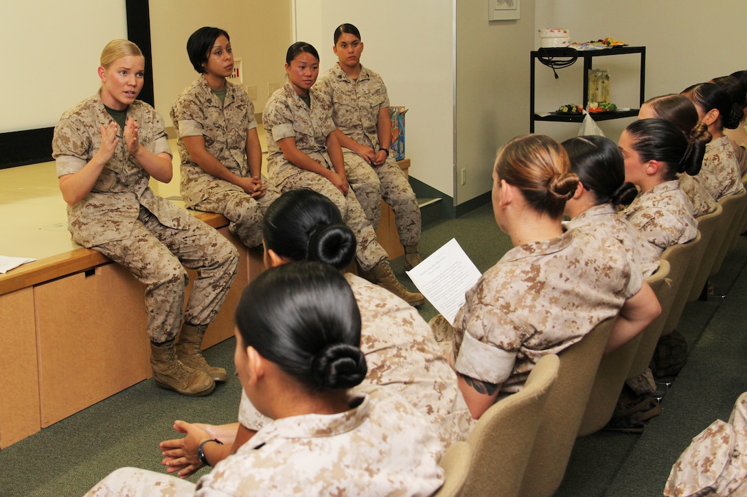 2nd Lt. Shannon L. Gross, station Provost Marshal’s Office services officer (left), Staff Sgt. Anabell Nevels, station freight operations chief, Warrant Officer Jana Tang, station installation administration personnel officer, and Sgt. Andrea M. Olguin, station combat camera photographer, address service members during a Women’s Equality Day assembly at the Building 1 Auditorium here Aug. 26.