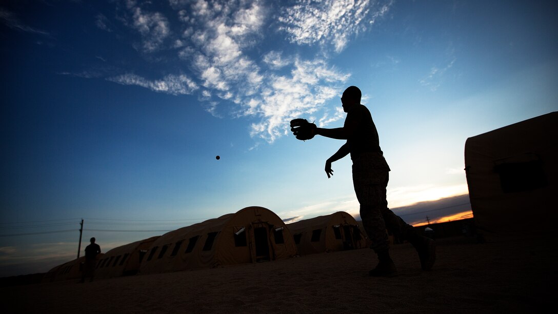 Lance Cpls. Cody Varnell and Nick Lacarra, military working dog handlers with Weapons Company, 3rd Battalion, 3rd Marine Regiment, toss around a baseball outside their sleeping quarters following a training day during the Mojave Viper exercise on Marine Corps Air Ground Combat Center Twentynine Palms, Calif., Aug. 25, 2011. By trade, both Marines are machine gunners. On their upcoming deployment, they’ll work with military working dogs to find improvised explosive devices before the IEDs can reign destruction. Though their pre-deployment training is exhausting, they make time every night for throwing around the baseball. The simple activity is their refresher from the grind of grunt life. “No matter how tired we are, we always have time for some relaxation and fun,” the 20-year-old Lacarra, from Long Beach, Calif., said. “Baseball is our way to unwind.” Varnell, 20, is from Mesquite, Texas. (Official U.S. Marine Corps photo by Cpl. Reece Lodder)