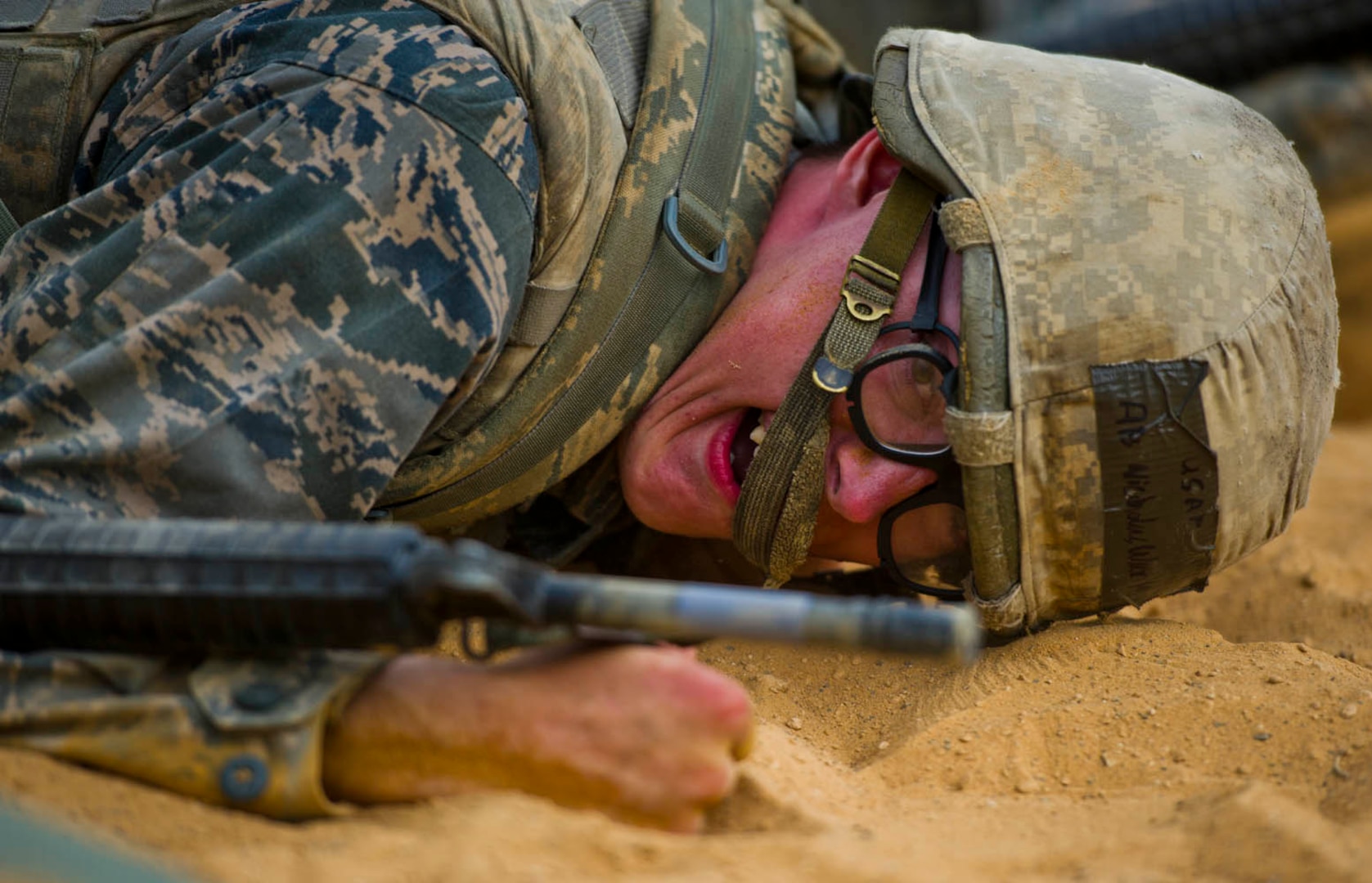 Air Force basic military trainee Nicholas Warila, 322nd Training Squadron, Flight 533, low crawls through an obstacle course during the Creating Leaders, Airmen and Warriors (CLAW) course July 27 at Lackland Air Force Base. CLAW is a three-hour, mission-oriented exercise designed to test teamwork, leadership skills and the ability to perform under pressure. (U.S. Air Force photo/Senior Airman Marleah Miller)