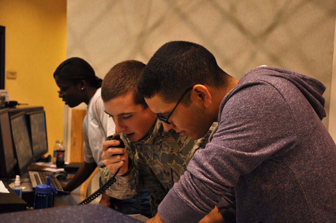 Senior Airman Michael Harrold, 633rd Communications Squadron, and Airman 1st Class Daniel Hernandez, 633rd Force Support Squadron, test communications at the Shellbank Fitness Center at Langley Air Force Base, Va., as Hurricane Irene approaches the area Aug. 27, 2011. Irene made landfall in North Carolina becoming the first hurricane to hit the continental United States since 2008. (U.S. Air Force photo by Senior Airman Jason J. Brown/RELEASED)