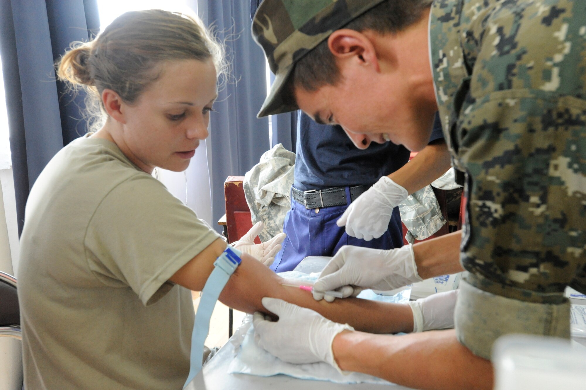 A Kyrgyz Republic soldier prepares to start an IV on Army Spc. Samantha Tougas during a medical information exchange at the Kyrgyz Ministry of Emergency Services Aug. 25. Tougas is deployed here from the Montana Army National Guard. (U.S. Air Force photo/Tech. Sgt. Tammie Moore)