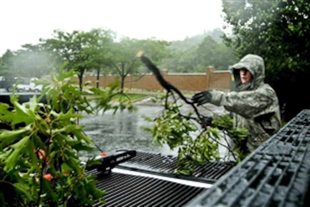 U.S. Air Force Senior Airman Joshua Garner cleans up tree branches knocked loose during heavy rains and winds from Hurricane Irene at Joint Base Anacostia-Bolling in Washington, D.C., Aug. 27, 2011. Garner is a pavement and equipment operator from Joint Base Anacostia-Bolling Public Works.