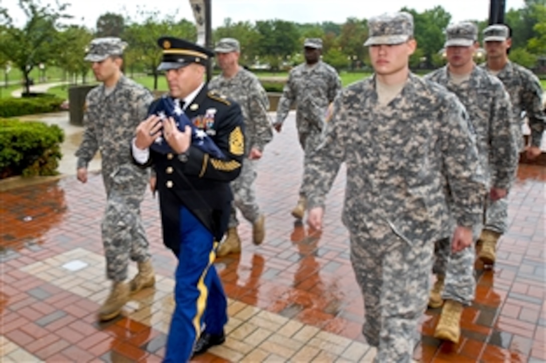 Army Command Sgt. Maj. Rodolfo R. Delvalle, center, marches with honor guard members as he holds the U.S. flag after it was lowered for the final time at Walter Reed Army Medical Center in Washington, D.C., Aug. 27, 2011. Delvalle is Walter Reed's command sergeant major.