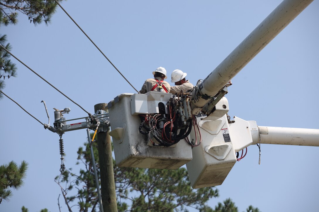 Contractors work on power lines at Marine Corps base Camp Lejeune on Aug. 28.